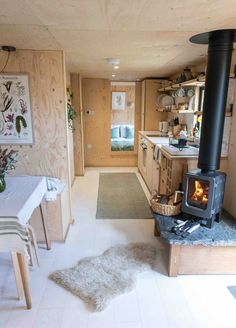 a kitchen with a wood stove in the center and a dining table to the side