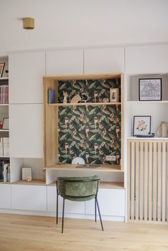 a living room with bookshelves, shelves and a chair in front of it