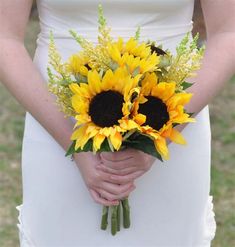 a bride holding a bouquet of sunflowers in her hands