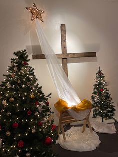 there is a cross on the wall next to a christmas tree