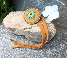 Flower Beaded Ponytail Tie, Would be pretty for a Wedding or Ceremonial Event. It is made with Soft brushed Caramel Brown Deerskin leather. I used high quality Czech Glass seed Beads, Colors are Green, Shades of blues, Yellows, Dark Brown and Carmel brown. This is made to tie around your Ponytail after you use an elastic to hold your hair. Or use to tie around your braided hair. Rosette Flower Measurement is 2 1/16" wide. Each tie measures about 9 1/2" long. Would be pretty for a Wedding or Cere Beaded Ponytail, Rosette Flower, Carmel Brown, Beads Colors, Beadwork Designs, Leather Tie, Green Shades, Braided Hair, Caramel Brown