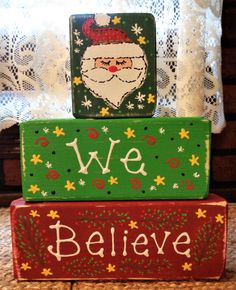 three wooden blocks stacked on top of each other with the words we believe and santa claus