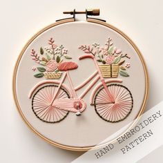 a pink bicycle with flowers in the basket on it's front and back side