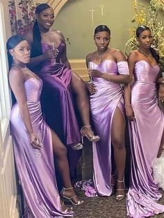 four women in purple dresses posing for the camera