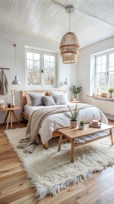 a bedroom with white walls, wooden floors and a large bed in the middle of it