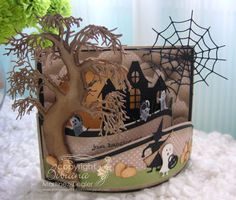 a card with a halloween scene on it and a spider web in the background,