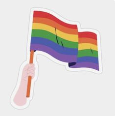 a hand holding a rainbow flag sticker