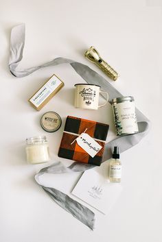 an assortment of personal care items laid out on a white surface with a gray ribbon