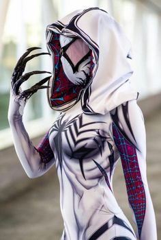 a woman dressed in spider - man costume holding her hands up