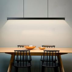 two bowls sit on top of a wooden table with four black chairs in front of it