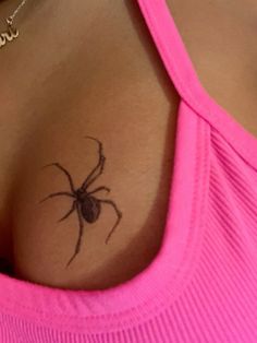 a woman's chest with a spider tattoo on her left shoulder and right breast