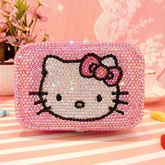 a hello kitty purse sitting on top of a table next to some candy candies