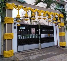 a gate decorated with yellow flowers in front of a building