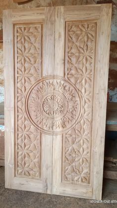 an intricately carved wooden door is shown in the process of being made with wood