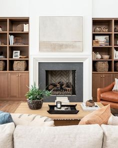 a living room filled with furniture and a fire place in front of a book shelf