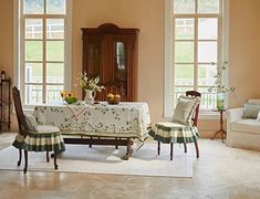 a dining room table and chairs in front of three windows