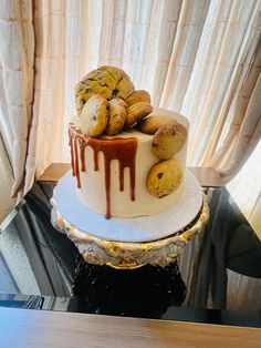 a three tiered cake with cookies and chocolate drizzled on the top