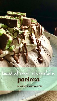 a cake with chocolate and green frosting sitting on top of a blue plate that says loaded mint chocolate pavlova