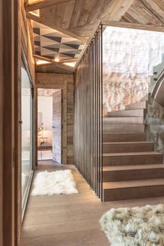 the stairs are made of wood and have sheepskin rugs on each one side