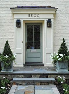 a front door with two planters on either side and the number 3500 above it