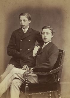 an old photo of two men sitting next to each other