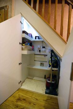 an open closet under the stairs in a house