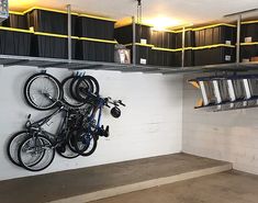 two bikes are hanging on the wall in a bike storage area with metal shelving