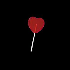 a red heart lollipop on a black background