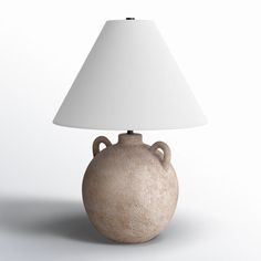 a lamp that is sitting on top of a white table cloth next to a brown vase