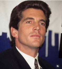 a man in a suit and tie looking off to the side with his eyes open