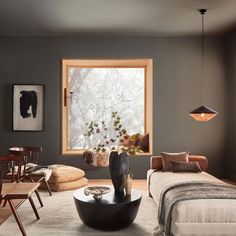 a living room filled with furniture and a large window in the middle of the room