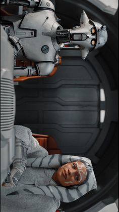 a star wars action figure laying on the ground next to a robot in a space station