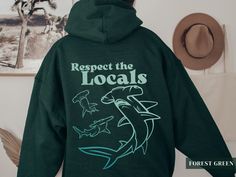 "This hoodie features a stunning ocean-colored gradient graphic design that showcases the outlines of Hammerhead sharks and the text \"Respect the Locals\".  It's perfect for those who are passionate about advocating for ocean and marine habitat conservation. Did you know that oceans produce 50% of the oxygen we breathe and absorb 25% of carbon dioxide? This makes ocean conservation vital for the survival of our planet!  Not only is it a statement piece with an important message, but this cozy and warm sweatshirt is perfect for throwing on whenever you need something comfy to cuddle up in! .: 50% cotton, 50% polyester (soft, warm, and comfy!) .: Medium-heavy fabric .: Classic unisex fit - Please reference the size chart in the photos or feel free to reach out to me with any sizing question Gifts For Ocean Lovers, Gradient Graphic Design, Hammerhead Sharks, Shark Whale, Beach Pullover, Respect The Locals, Gradient Graphic, School Clothing, Shark Hoodie