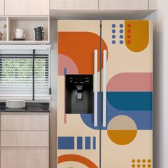 a colorful refrigerator in the middle of a kitchen