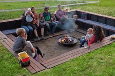 a group of people sitting around a fire pit