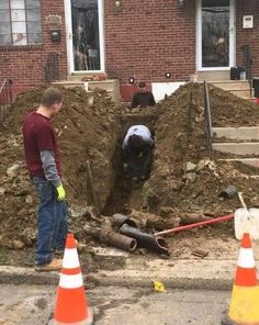 a man standing next to a pile of dirt