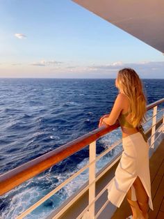 a woman standing on the deck of a cruise ship looking out at the ocean