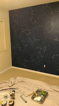 the wall is being painted with stars and paintbrushes on it's surface