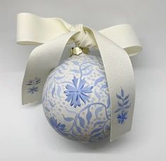 a blue and white ornament with a ribbon tied around it