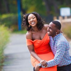 a man and woman standing next to each other on the street smiling at each other