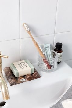 a bathroom sink with soap, toothbrush and other personal care items sitting on it