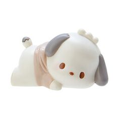 a white and gray dog figurine laying on its back with it's eyes closed