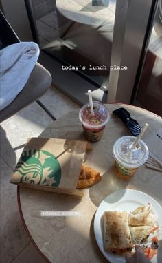 a table with some food on it and a drink in a plastic cup next to it