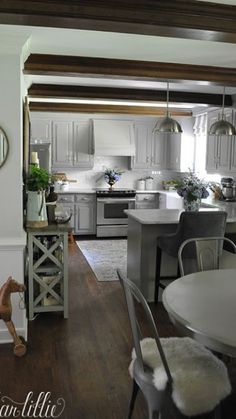 an open kitchen and dining room with white cabinets