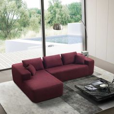 a living room filled with furniture next to a large glass window overlooking a swimming pool