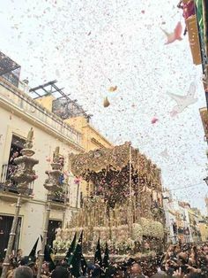 confetti is thrown in the air as people walk down a crowded city street