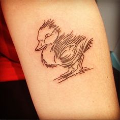 a tattoo on the arm of a woman with a bird in it's beak