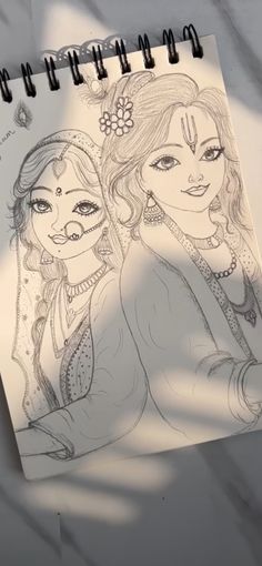 a drawing of two women with long hair and makeup on the cover of a notebook