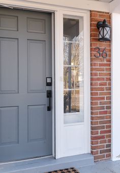 the front door is painted gray and has two sidelights on either side of it