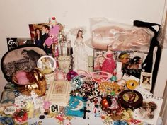 a table topped with lots of assorted items next to a white wall in a room